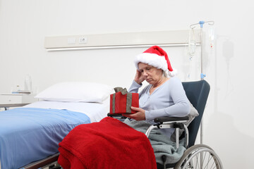Christmas day isolated in hospital room with coronavirus, sad and pensive elderly woman on...