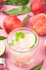 Summer cold alcohol beverage, iced peach Bellini cocktail with mint leaves,