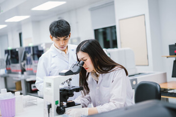 Fototapeta na wymiar Two medical scientist working in Medical laboratory , young female scientist looking at microscope