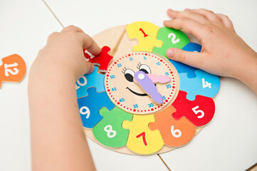 Boy learning time with wooden clock. Toy for Learning method for Children Education. Preschool or special needs tasks. Montessori methodology.