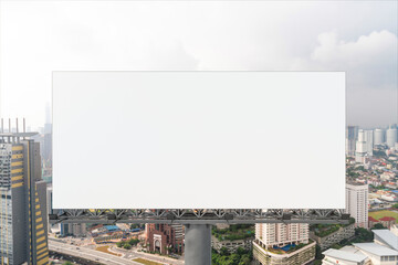 Fototapeta premium Blank white road billboard with KL cityscape background at day time. Street advertising poster, mock up, 3D rendering. Front view. The concept of marketing communication to promote or sell idea.