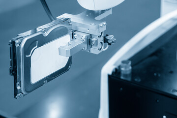 The automatic robotic arm gripping the hard disk part in production line. The hi technology...