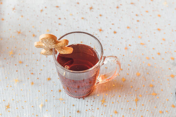 Cookie on the rim of a tea mug on a festive background