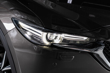 Fototapeta na wymiar Black car headlights. Exterior detail. Close up detail on one of the LED headlights modern car..