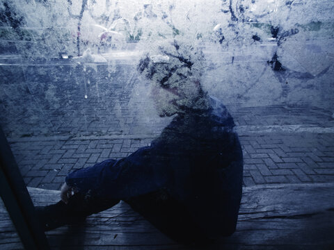Man sitting behind a blurred glass - introvert man - phobia social - depressive man - confused mind