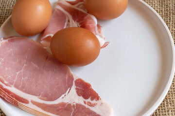 uncooked bacon and eggs 