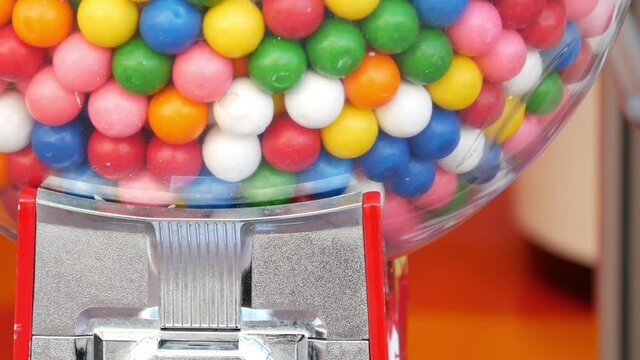 Colorful gumballs in classic vending machine, USA. Multi colored buble gums, coin operated retro dispenser. Chewing gum candies as symbol of childhood and summertime. Mixed sweets in vintage automate.