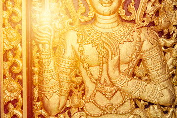 Thai woodcraft golden art god pattern at temple door Buddhist religion culture pattern for background