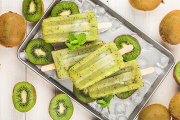 Kiwi ice cream popsicle on top of wooden board background