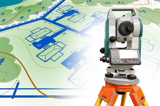 Total station close-up. Total station on the ground plan. Concept - provision of tapographic services. Total station is mounted on a tripod. Sale of equipment for tapography. Concept - cadastral work