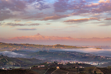 Fototapeta na wymiar Monviso at Sunrise and Langhe region, with vineyards. Panoramic sunset in Piemonte (Piedmont). Italian Alps. Distric of Cuneo and Alba in Italy.