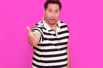 Caucasian man wearing casual striped t-shirt standing over isolated hot pink background shows...