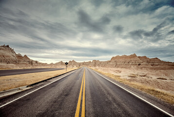 Scenic road in Badlands National Park, color toning applied, travel concept, USA.