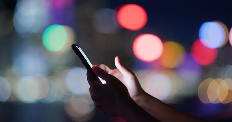Woman use of smart phone over city night background