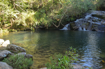 Small waterfall with a beautiful natural pool near a small village in Brazil.