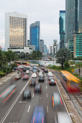 Cars captured with blured motion drive around the Plaza Indonesia roundabout in Jakarta.