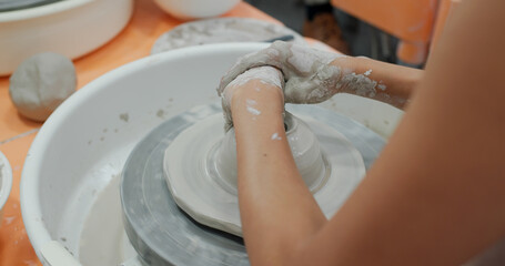 Hand work on pottery wheel, shaping a clay pot