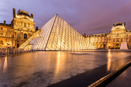 PARIS, FRANCE - AUGUST 4, 2016: The Louvre Palace at night with its famous pyramid  in Paris, France capital city.