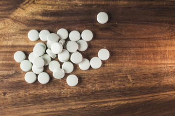 Fototapeta na wymiar Top view of a stack of pills on a wooden surface