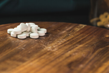Fototapeta na wymiar White pills on a wooden surface, apothecary. 