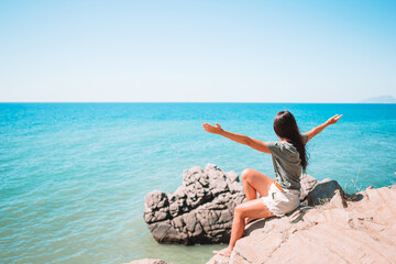Tourist woman outdoor on edge of cliff seashore