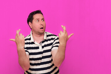 Caucasian man wearing casual striped t-shirt standing over isolated hot pink background shows various gestures.