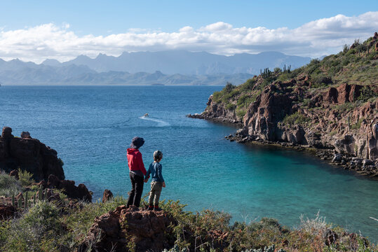 A woman and her son standing on a rock at a beach in Del Carmen Island