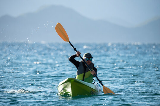 One woman paddling on a seat on top kayak close to the shore of Carmen Island in Loreto, Baja California, Mexico.