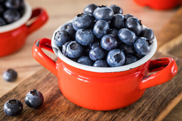 Fresh blueberries in a pot on the table, old wood