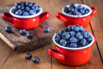 Fresh blueberries in a pot on the table, old wood
