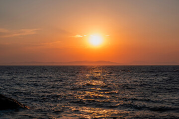 Sunrise, sunset. Twilight, dusk sky over sea water, mountain silhouette