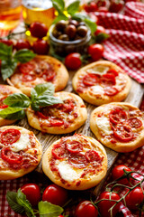 Small pizzas with cherry tomatoes and mozzarella cheese  close up view