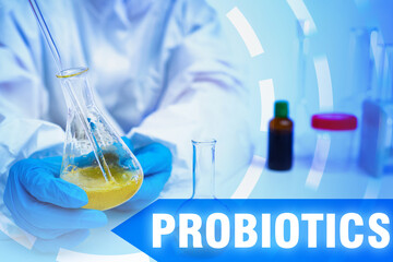 Probiotics. Lab technician holds flask with probiotics. Developing bowel supplements. Preparation...