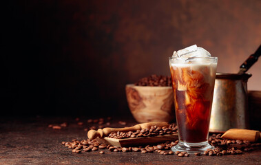 Ice coffee with cream being poured into it showing the texture and refreshing look of the drink.