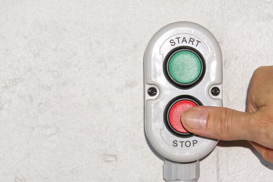 A finger pushing a stop button on production.