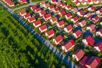 Suburb top view. Suburbia. Two-story houses in suburbs. Concept - low-rise buildings. Houses with red roofs on a summer day. Cottage village view from a quadcopter. Suburbia top view. Suburban homes