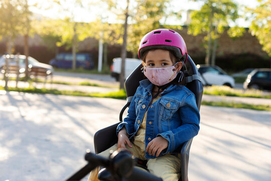 little girl wearing face mask ready for a bicycle ride
