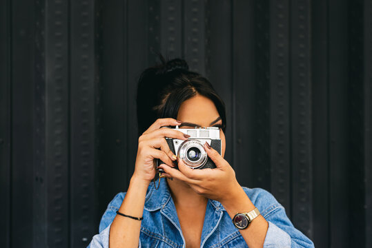 woman with an industrial background taking a photograph, camera