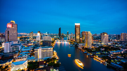 Naklejka premium Landscape of city and river in Bangkok, Thailand, cityscape at twilight time in aerial view of Bangkok skyline and skyscraper with light trails street
