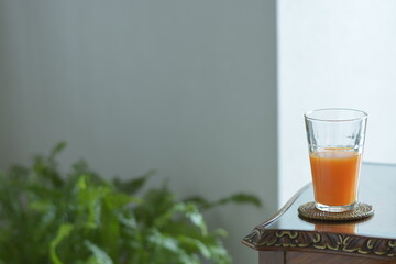 put a fruit juice on a antique mahogany table. window is bright.  This expensive furniture is made in England.  blurred background with copy space.