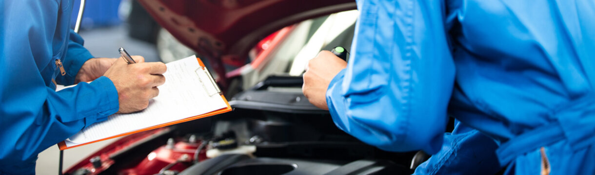 Banner of automotive mechanic men with assistant checking damage under-car condition, vehicle maintenance technician write on checklist document in garage at auto repair shop. after service concept