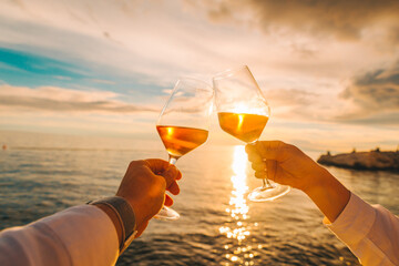 couple resting on sunset at sea beach and drinking wine
