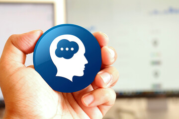 Brain head icon blue round button holding by hand infront of workspace background