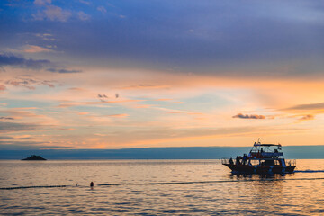 Obraz na płótnie Canvas people on boat enjoying the view of sunset