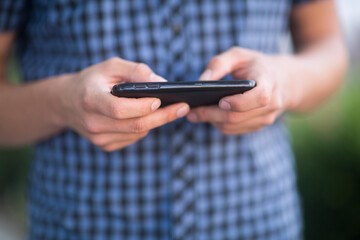 Junger Mann außen mit kariertem Hemd
