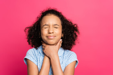 curly african american kid with closed eyes and hands on throat isolated on pink