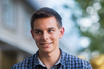 Junger Mann au&szlig;en mit kariertem Hemd
