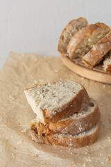 Loaf of homemade bread with sliced bread from wheat and seeds on parchment paper