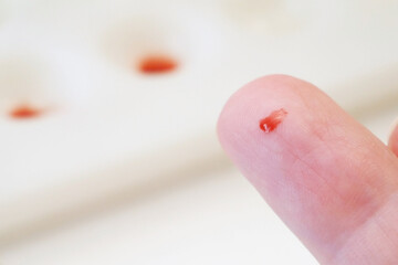 hand with red blood drop  on white background, medical test concept
