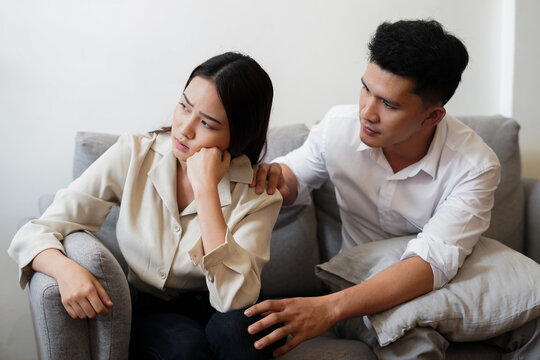 Upset and unhappy wife sit on sofa think of relationship problems and husband try to reconcile and sorry after quarrel family and couple problem